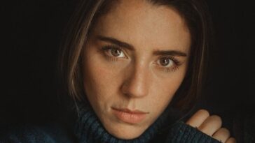 a woman in a blue turtle neck sweater