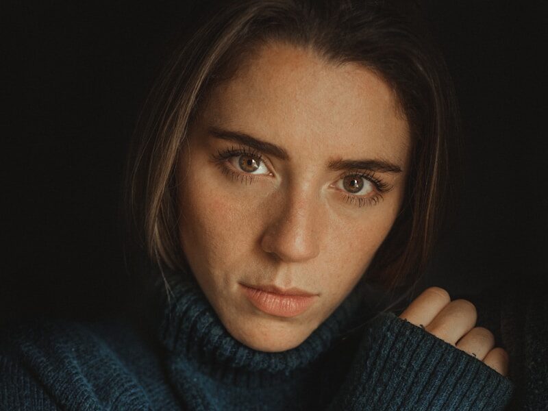 a woman in a blue turtle neck sweater
