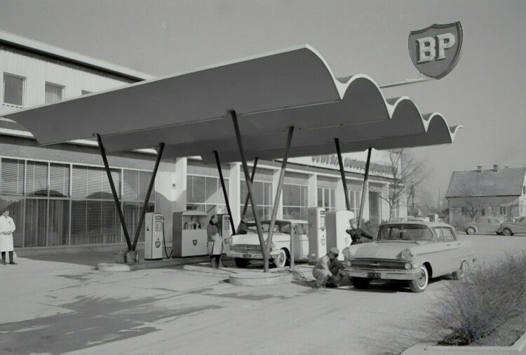 grayscale photo of cars parked near building