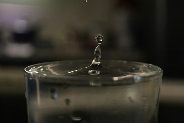 a drop of water falling into a glass of water