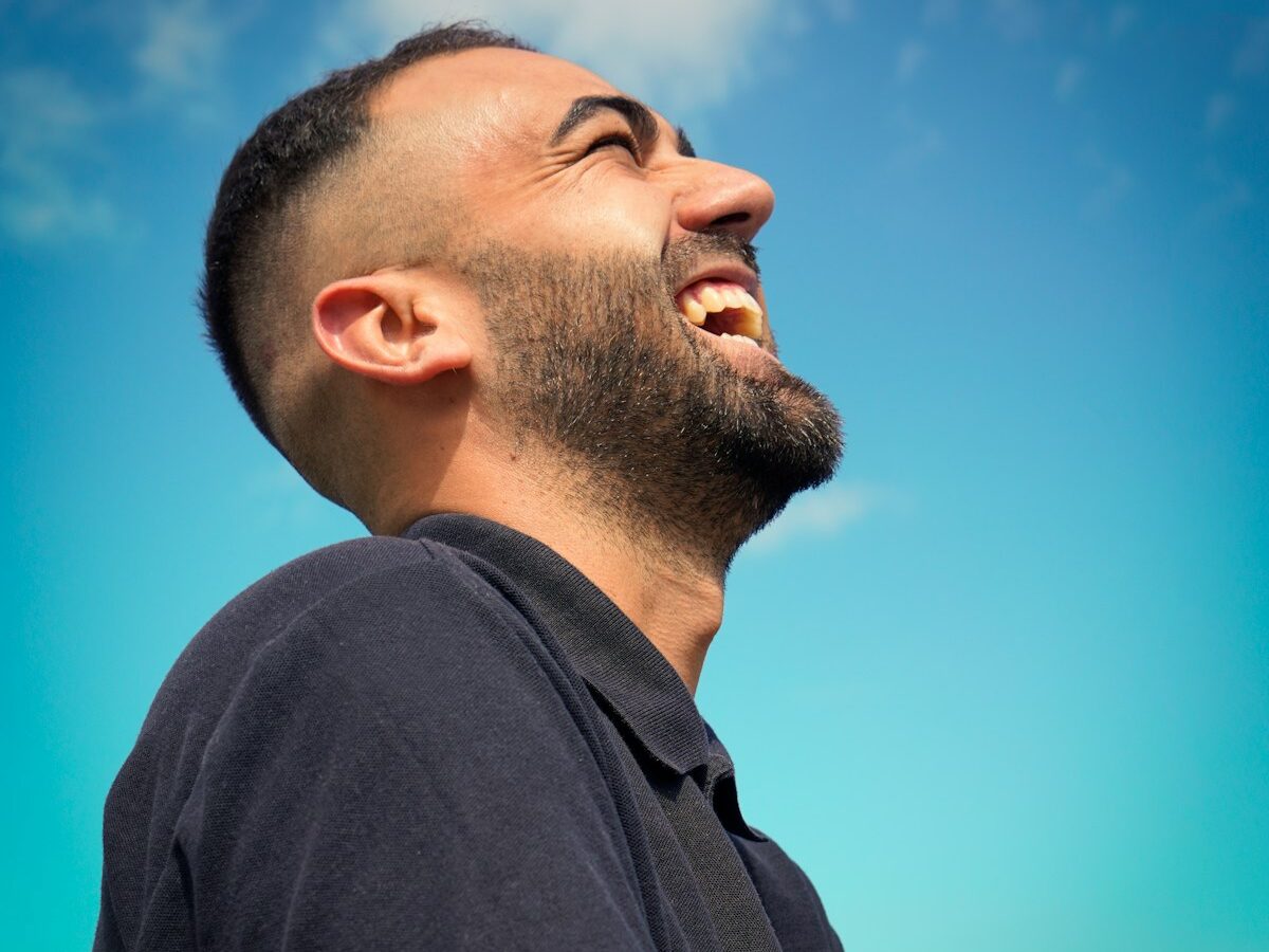 smiling man wearing black collared top