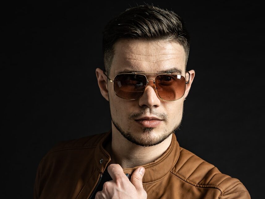 man in brown leather jacket wearing black sunglasses