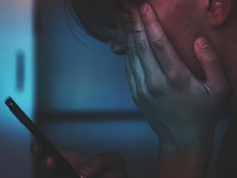 man holding smartphone in close up photography