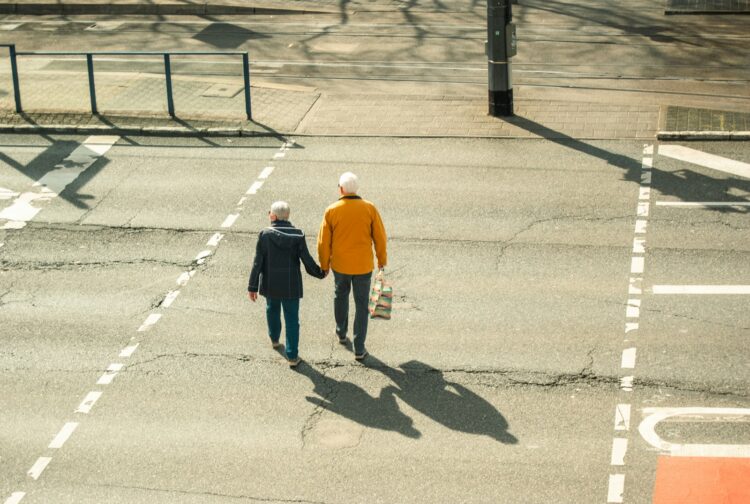 a couple of people walking across a parking lot