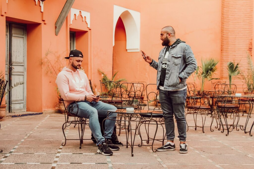 man in gray denim jacket sitting on chair beside woman in pink dress shirt