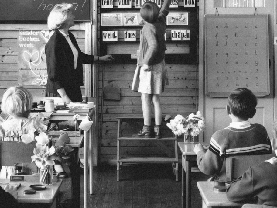 a black and white photo of children in a classroom