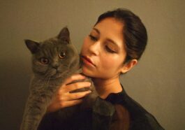 woman in black shirt holding gray cat