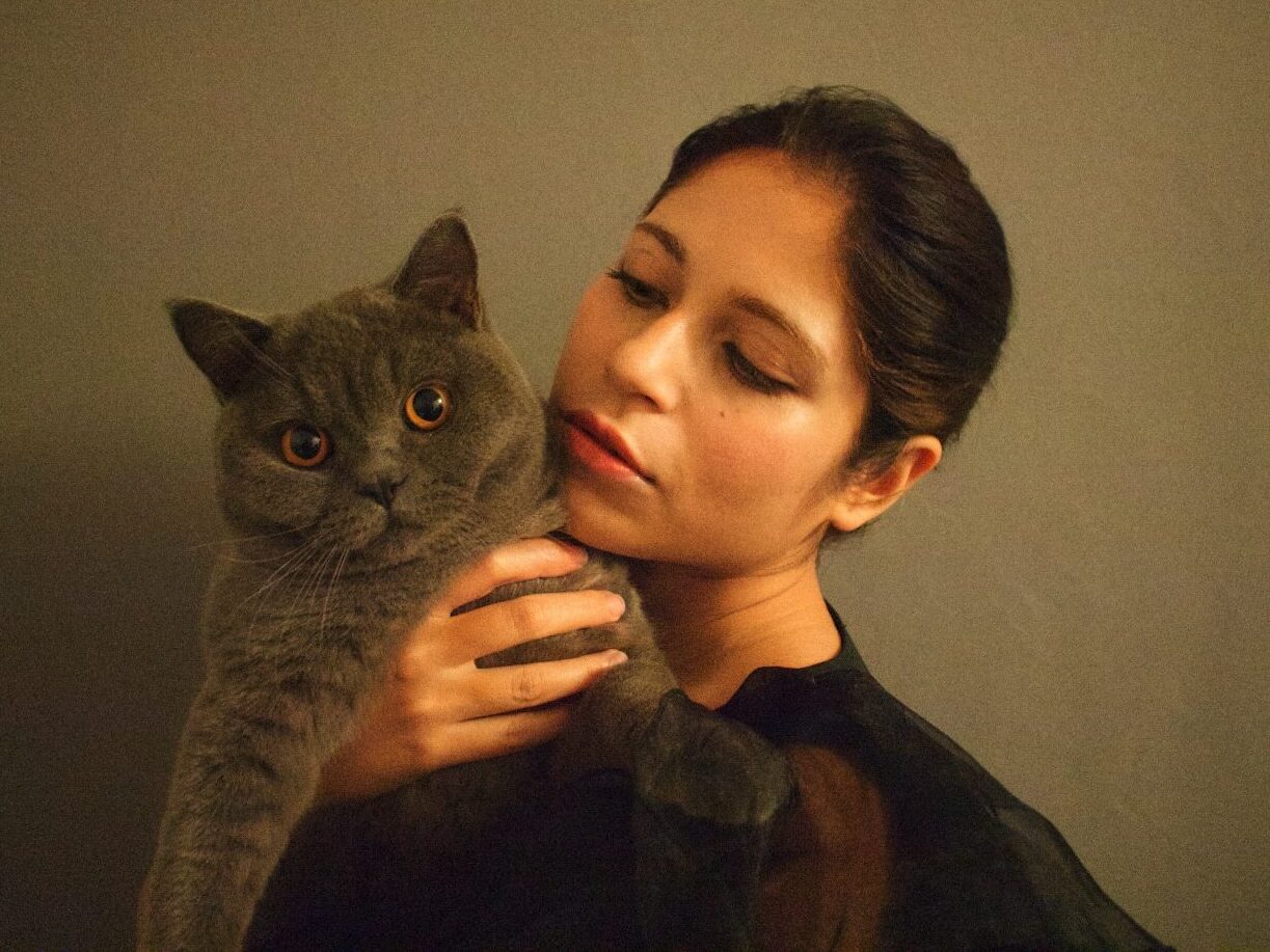 woman in black shirt holding gray cat
