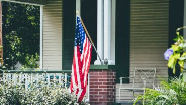 us a flag on white wooden fence
