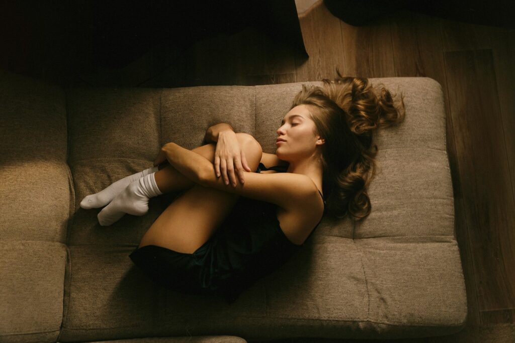 A woman laying on a couch with her legs crossed
