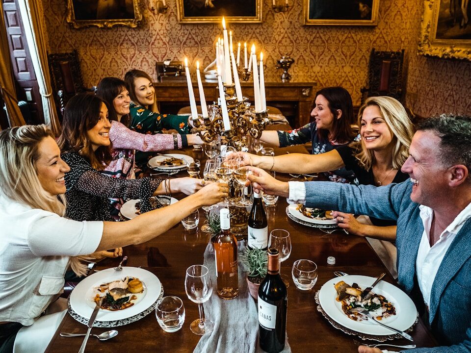 group of people sitting on chair in front of table with plates and drinking glasses