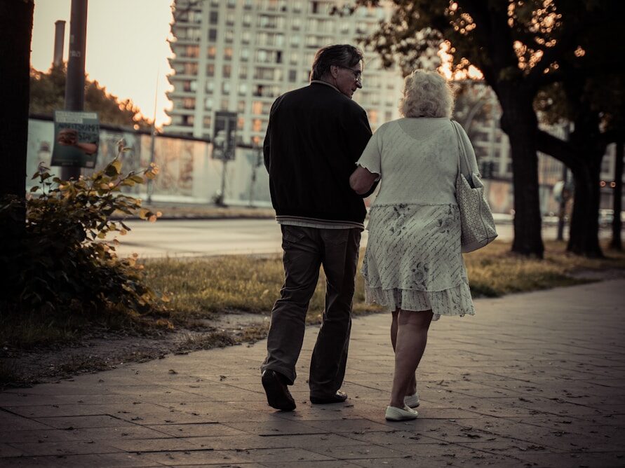 couple walking on sidewalk during daytime