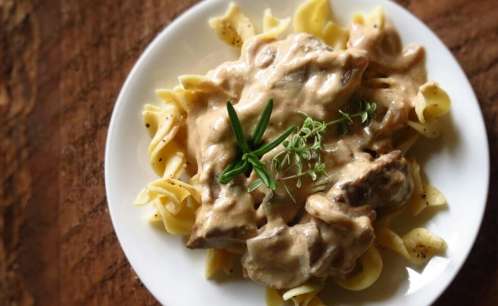 a white plate topped with pasta covered in sauce
