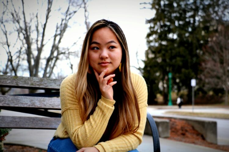 Young woman sitting on a park bench outdoors.