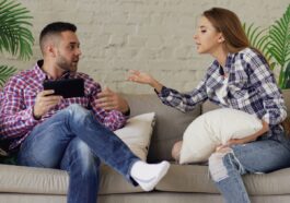 Couple arguing while sitting on a sofa