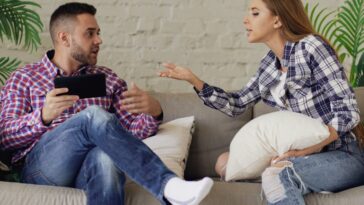 Couple arguing while sitting on a sofa