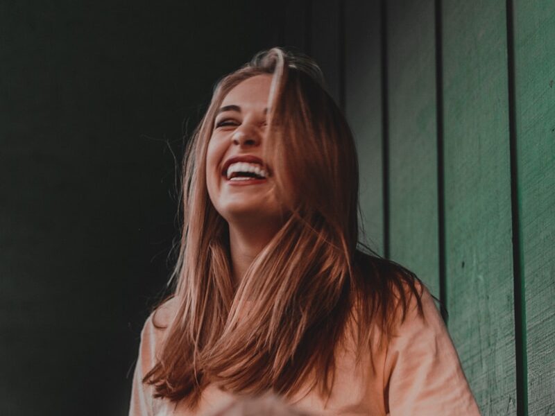 woman in orange shirt laughing