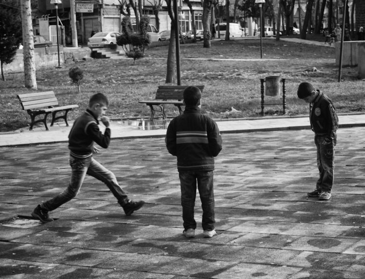 grayscale photo of 2 boys playing basketball