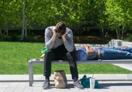 man sitting on white metal bench during daytime