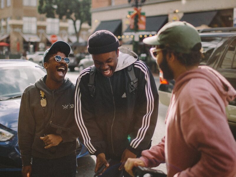 three men in jacket laughing at each other