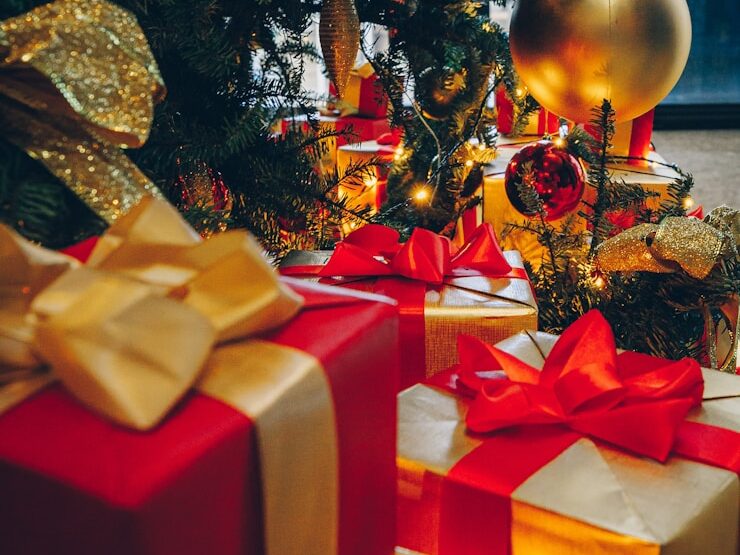 green Christmas tree with decorations and gift boxes on floor