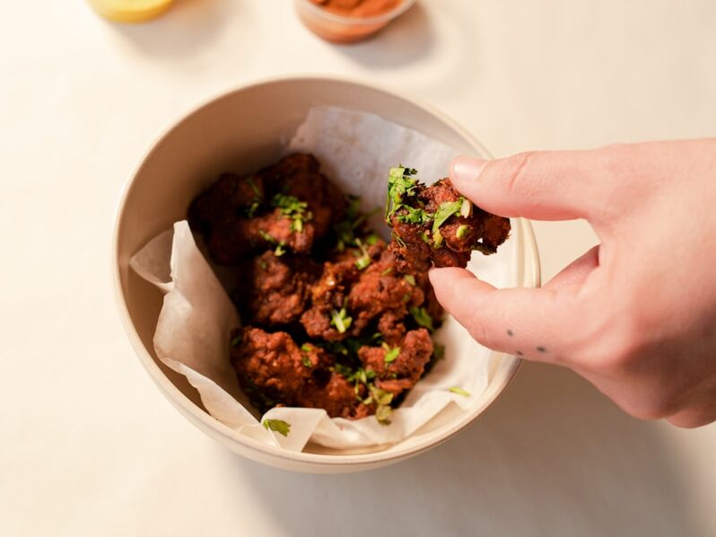 person holding white ceramic bowl with food