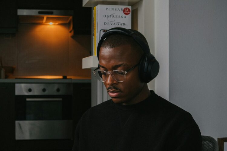 a man wearing headphones sitting in front of a laptop computer