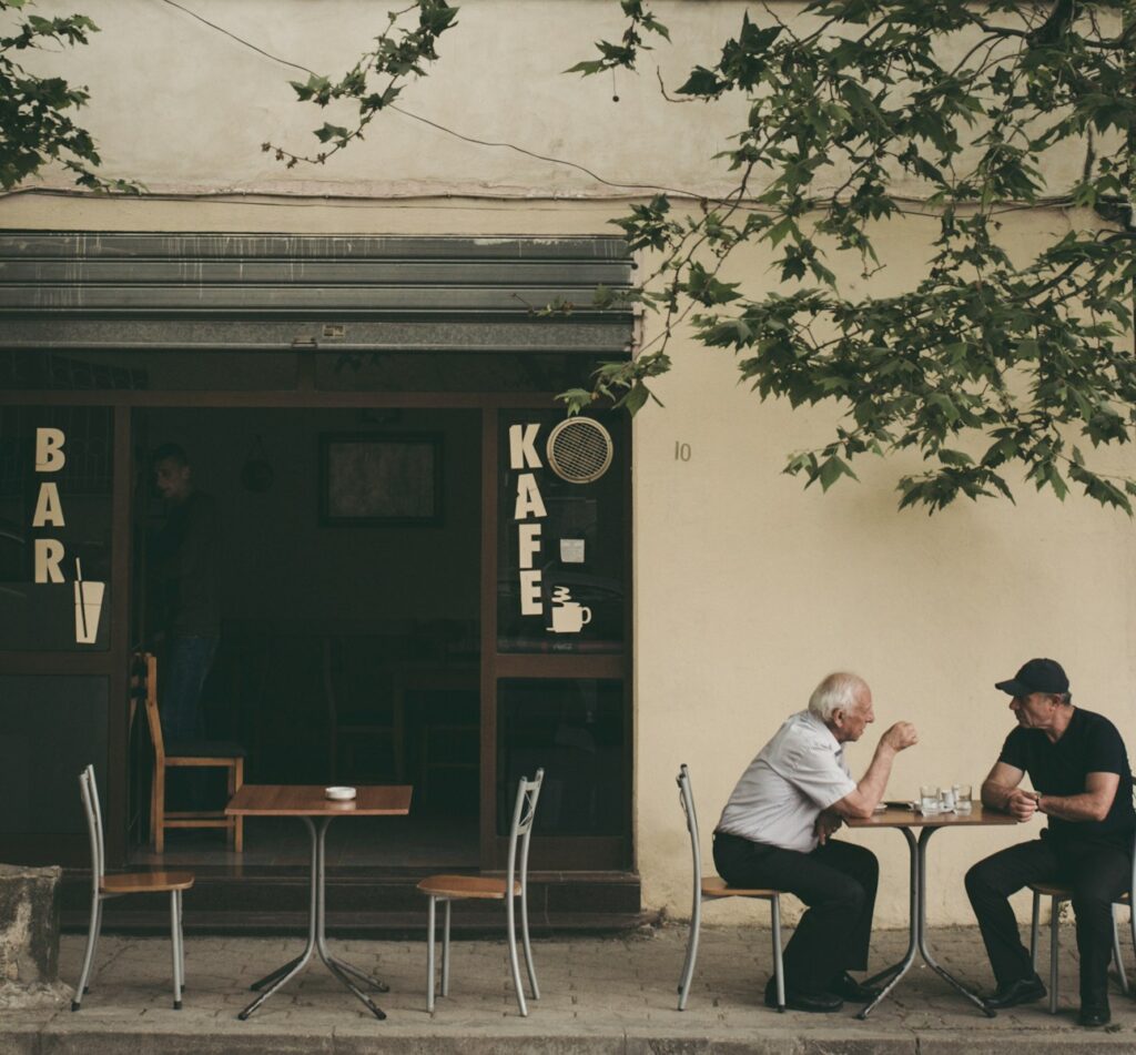 two man chatting white sitting on brown wooden chair