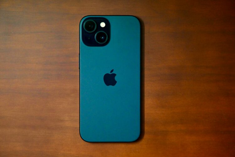 a blue iphone sitting on top of a wooden table