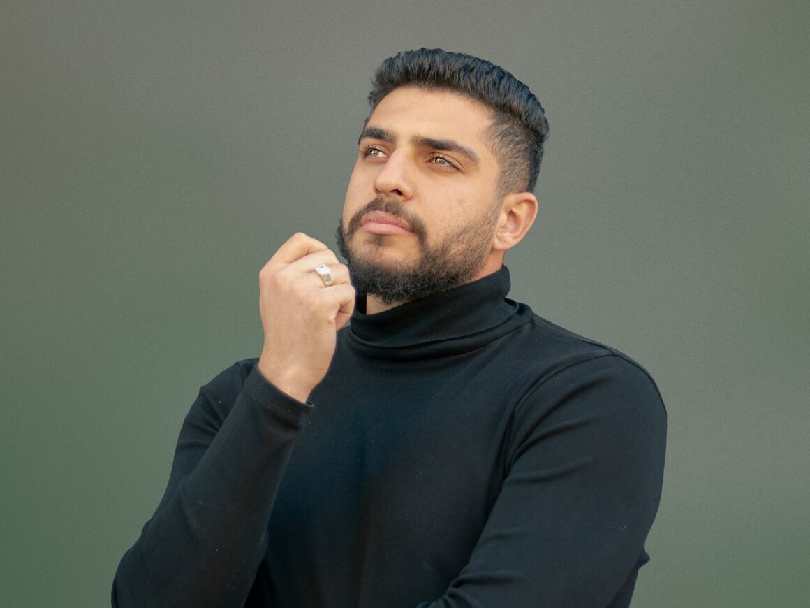 a man wearing a black turtle neck sweater