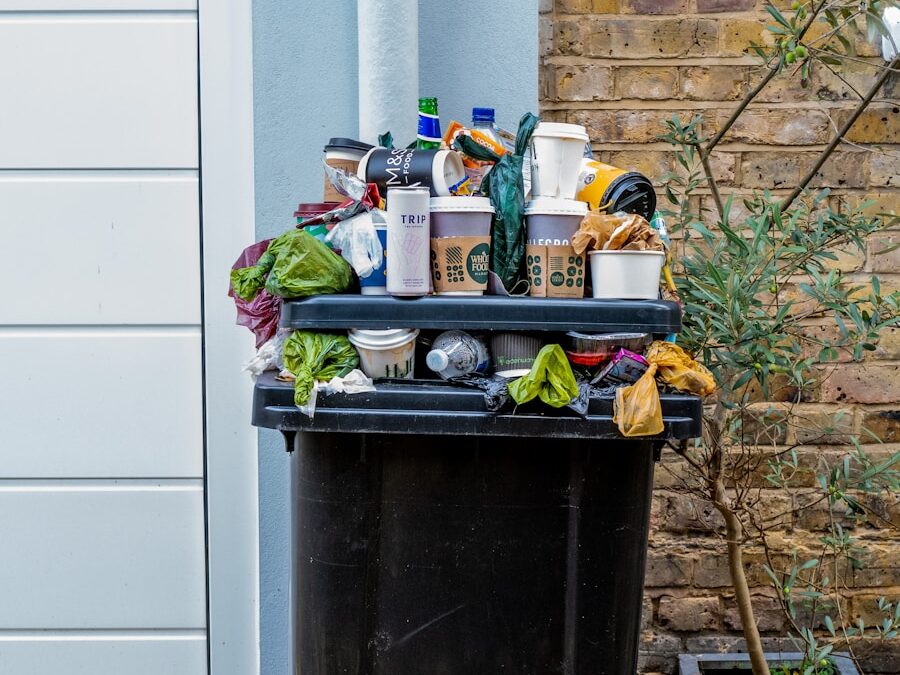 black trash bin with green leaves