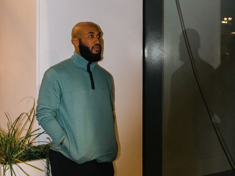 a man standing next to a plant in a room