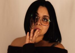 Woman with glasses touching her mouth