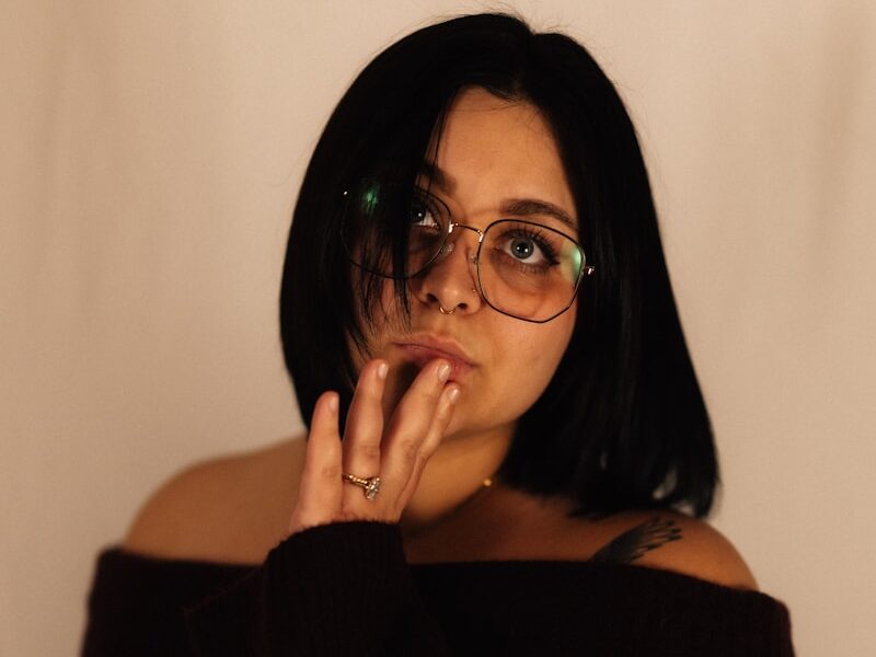 Woman with glasses touching her mouth