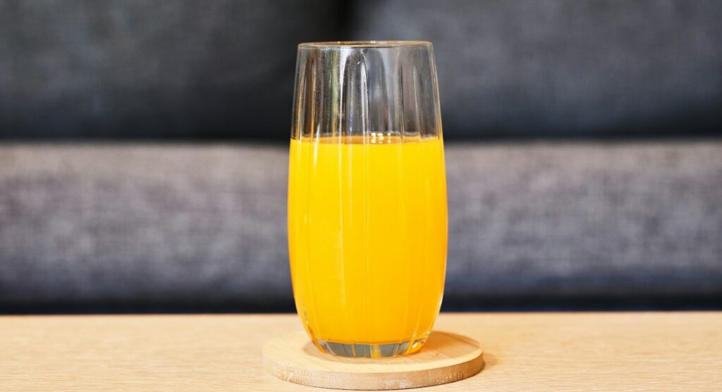 a glass of orange juice sitting on a table