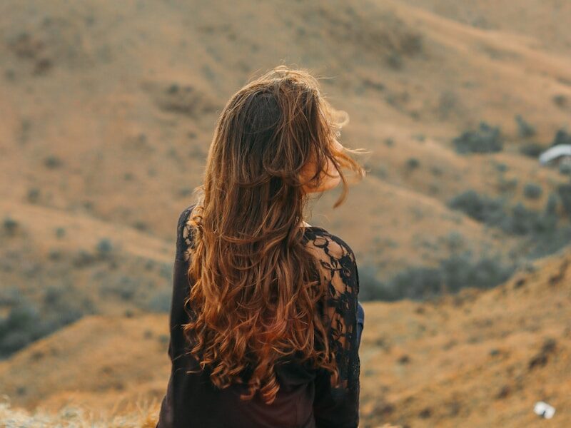 woman in black shirt looking at the mountains during daytime