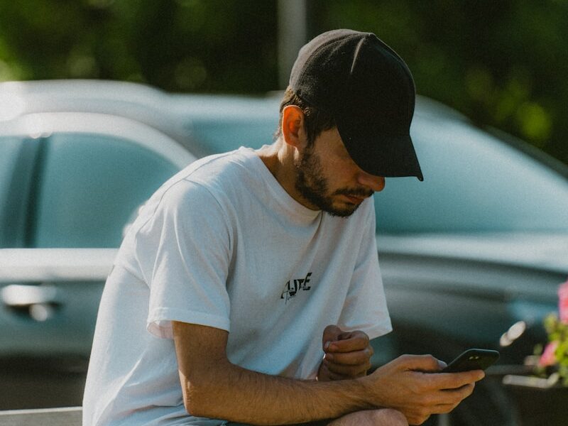 a man sitting on a bench looking at his cell phone