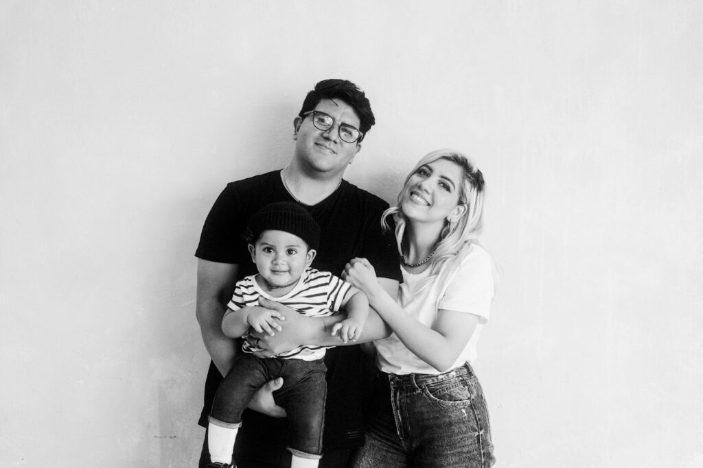 grayscale photo of man and woman carrying baby