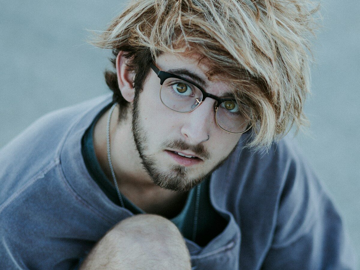 a young man with a messy haircut and glasses