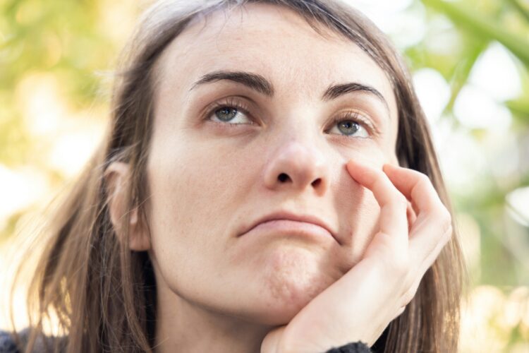 a close up of a person with a hand on their face