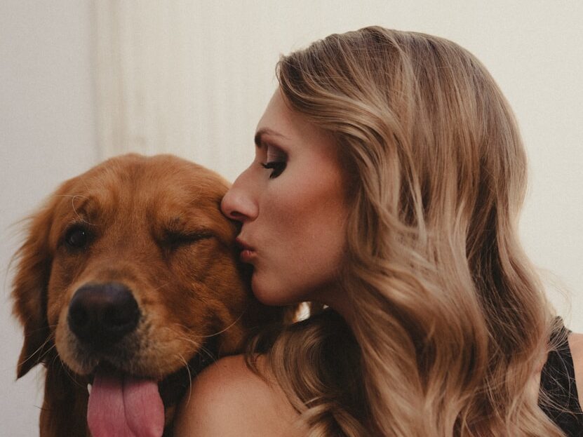 a woman kissing a dog