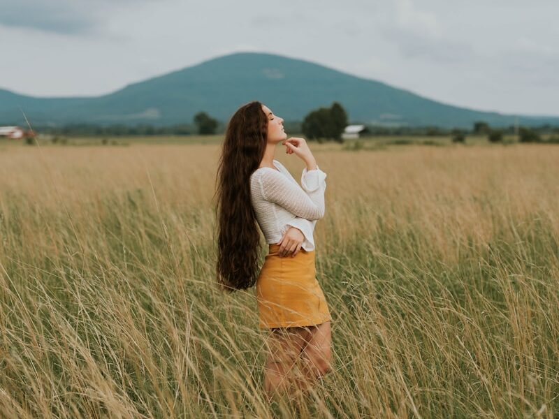 woman standing in the middle of grass field