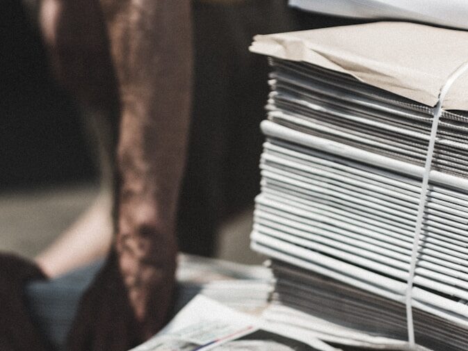 shallow focus photography of piles of newspapers