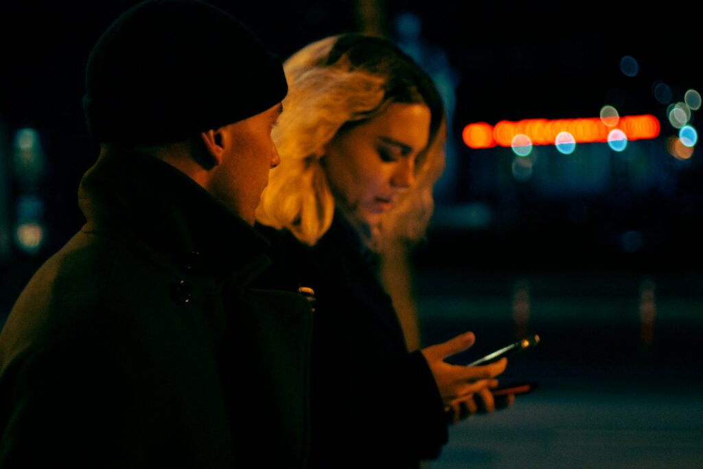 a man and woman looking at a cell phone