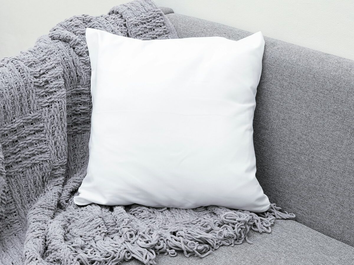 white throw pillow on gray sofa