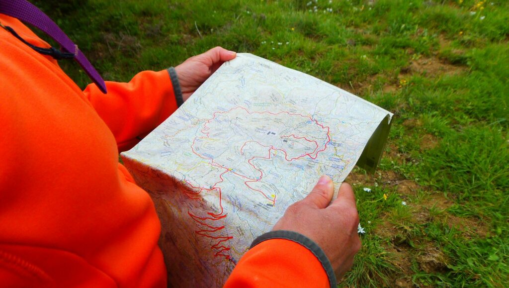 person in orange long sleeve shirt holding white printer paper