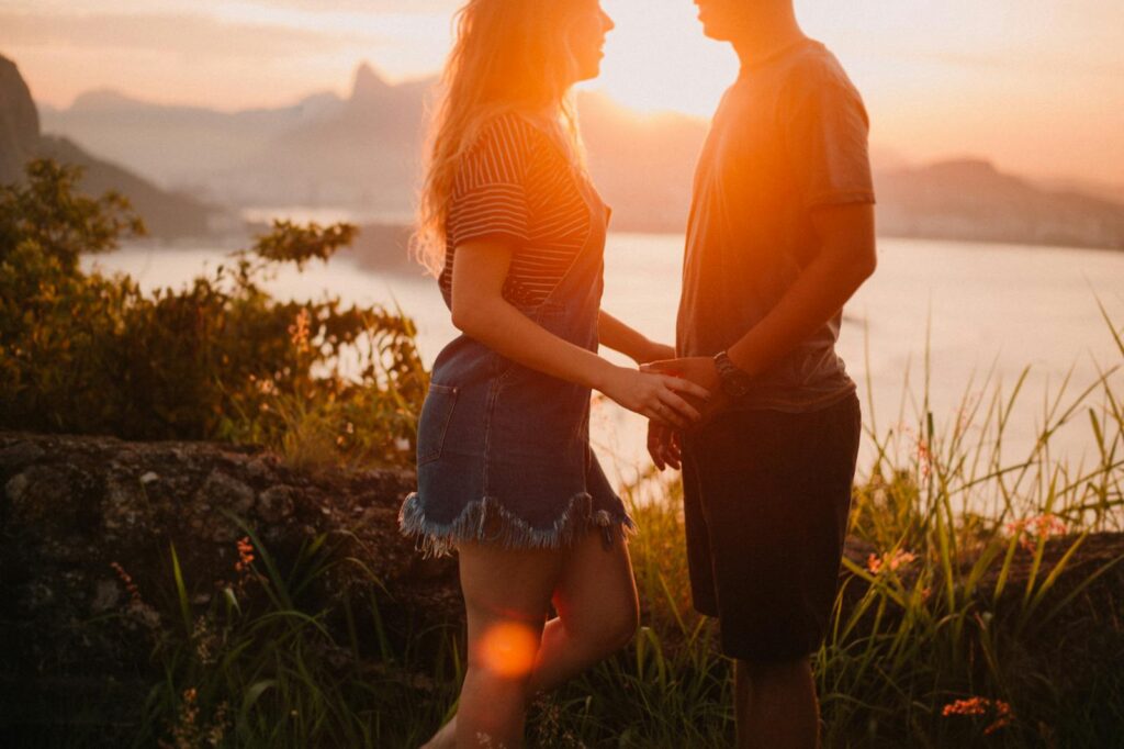 A couple enjoys a romantic sunset overlooking Rio's skyline in Jurujuba, Brazil.
