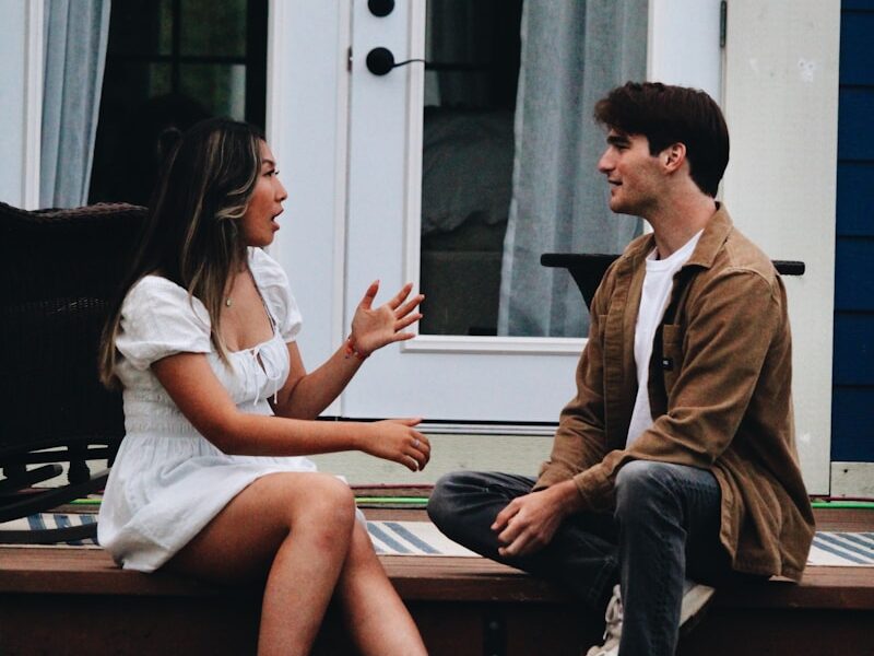 a man and woman sitting on a porch