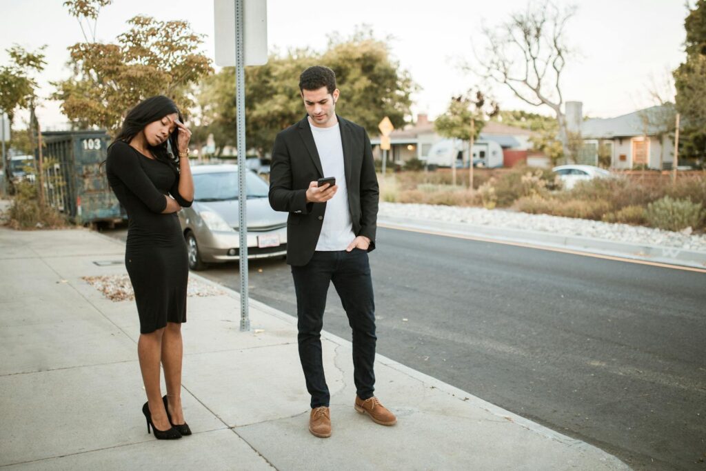 Interracial couple arguing on a city sidewalk, showcasing relationship tension.