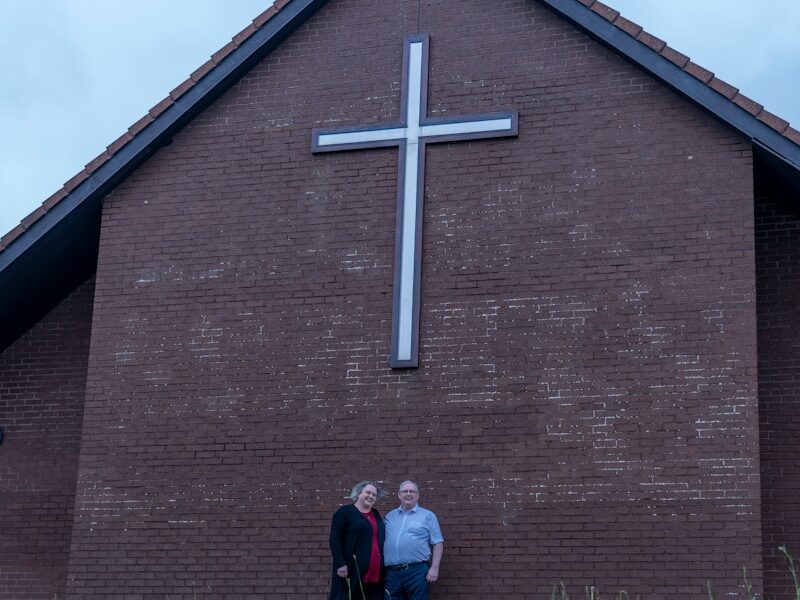 two people standing in front of a church